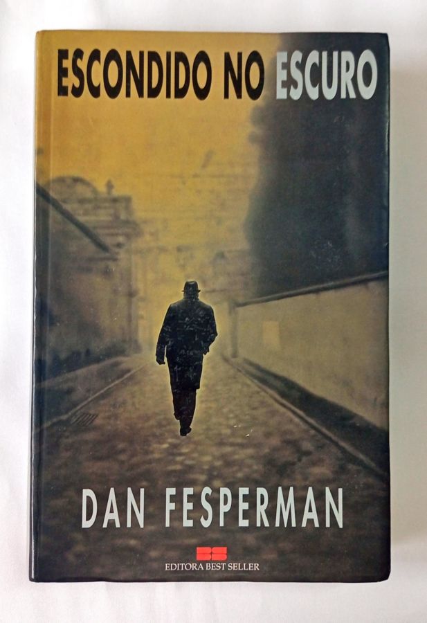 <a href="https://www.touchelivros.com.br/livro/escondido-no-escuro/">Escondido no Escuro - Dan Fesperman</a>