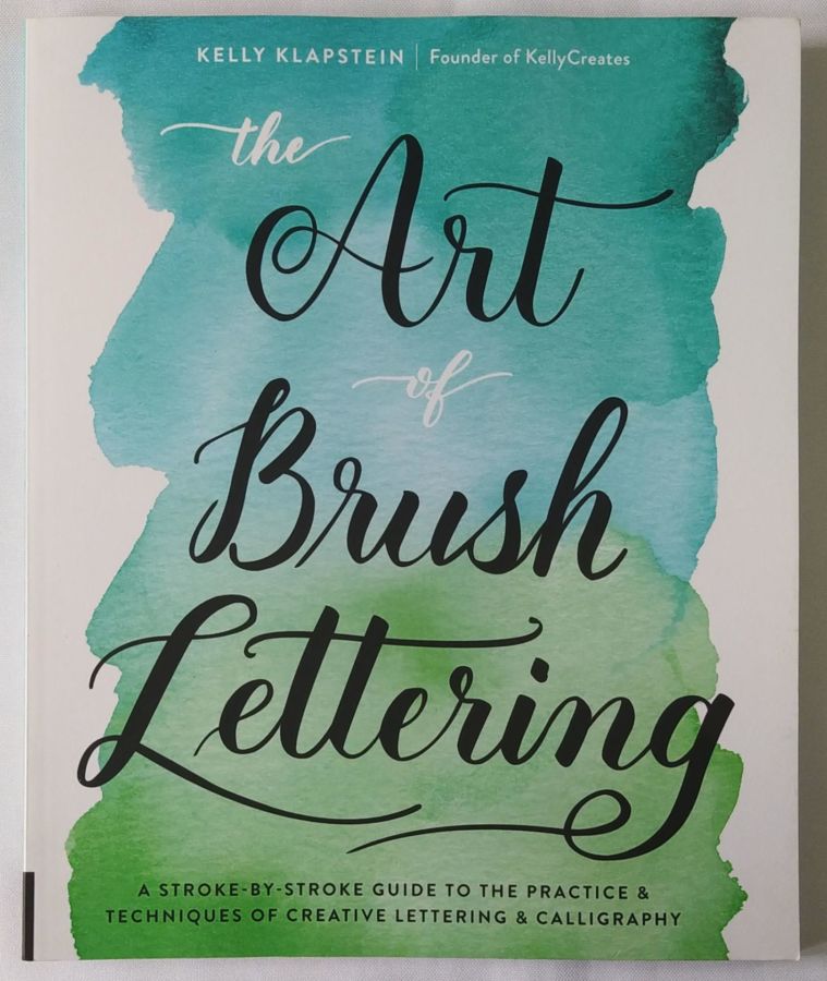 <a href="https://www.touchelivros.com.br/livro/the-art-of-brush-lettering/">The Art of Brush Lettering - Kelly Klapstein</a>